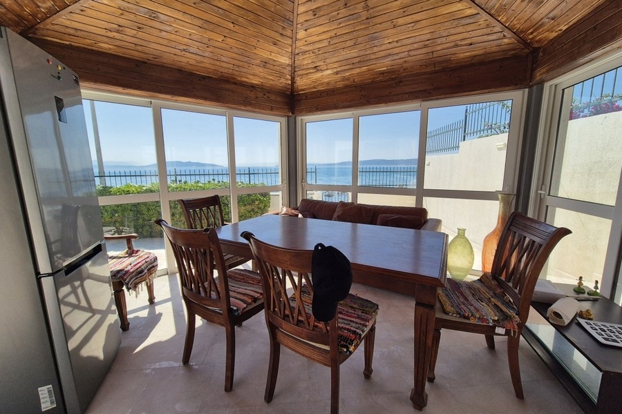 Glazed summer kitchen with dining table and sea view in Croatia