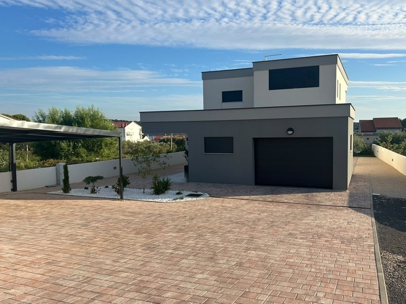 View of house with garage and paved forecourt