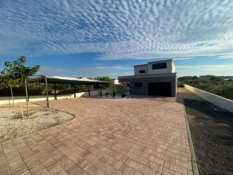 Forecourt with covered parking space and view of the house
