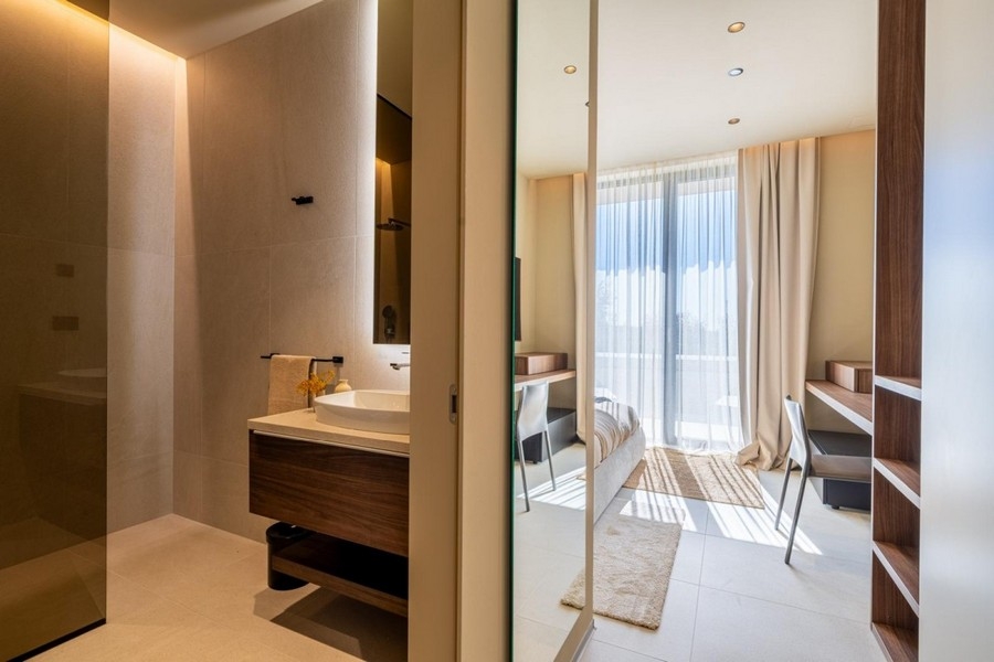 Bathroom with vanity and view into the bedroom
