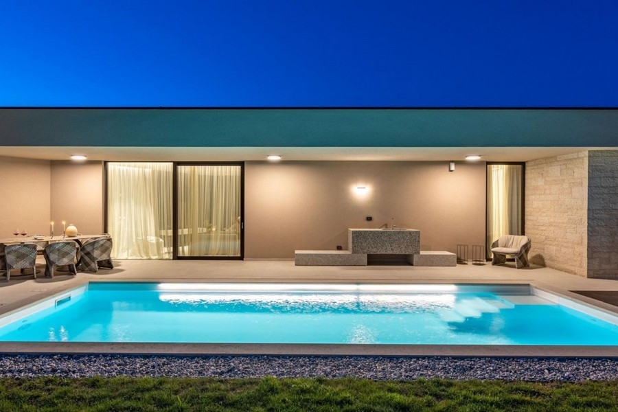 Illuminated pool and terrace of the villa near Porec in the evening
