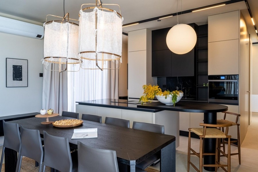 Dining table with designer lights in front of the open kitchen