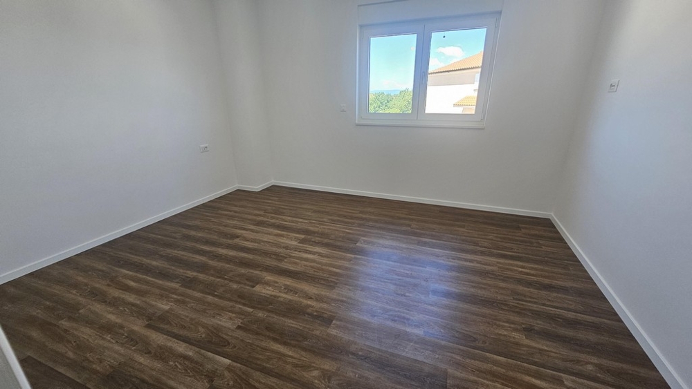Bedroom with window and wooden floor