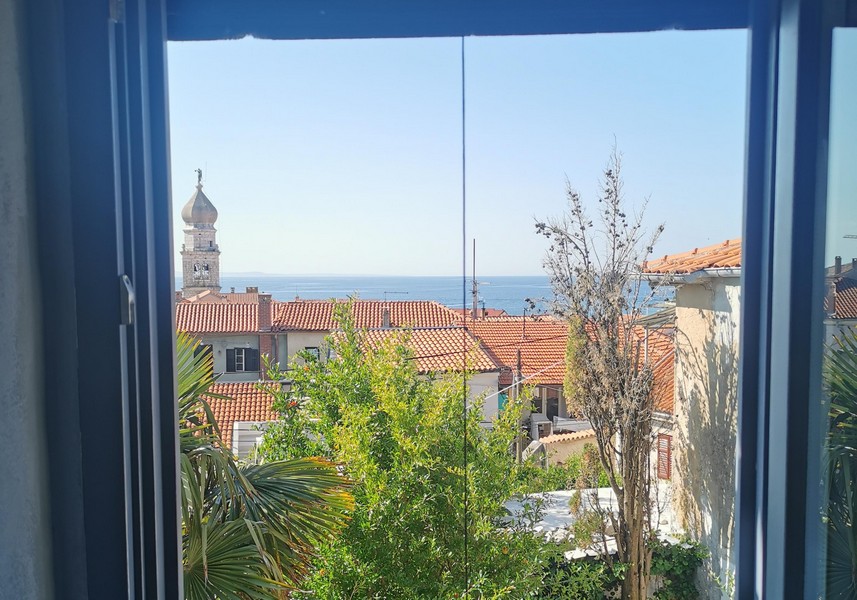 Window view of the sea and the old town of Krk with church tower