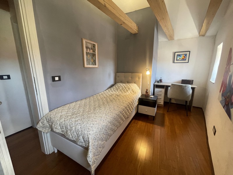 Bedroom with single bed and desk under the attic