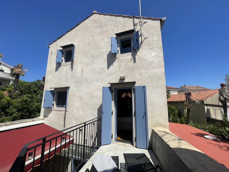 Stone house with light blue shutters and roof terrace in Krk