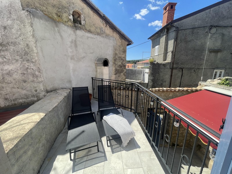 Terrace with loungers and a view over the roofs of Krk
