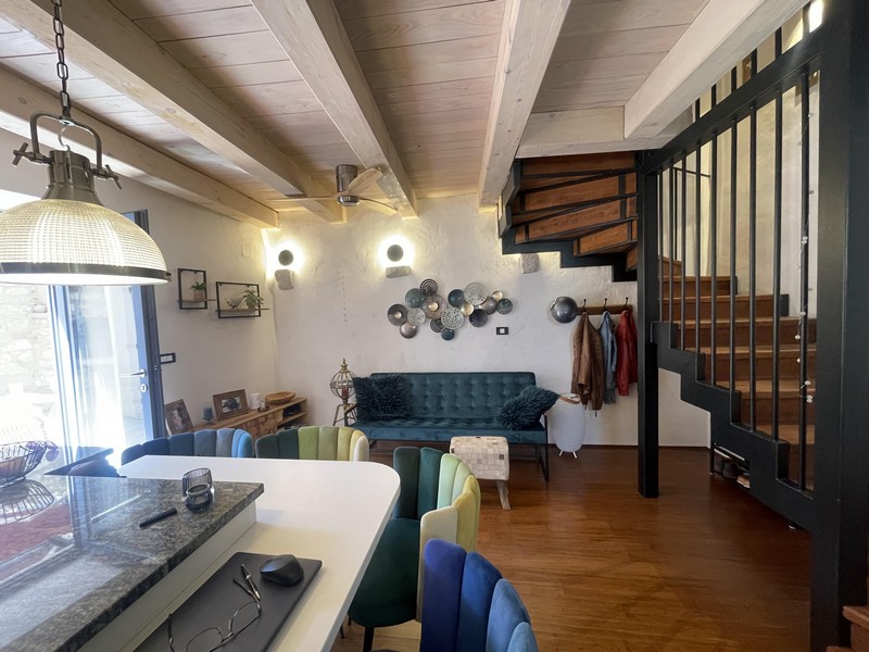 Living room with sofa, kitchen island and stairs to the upper floor