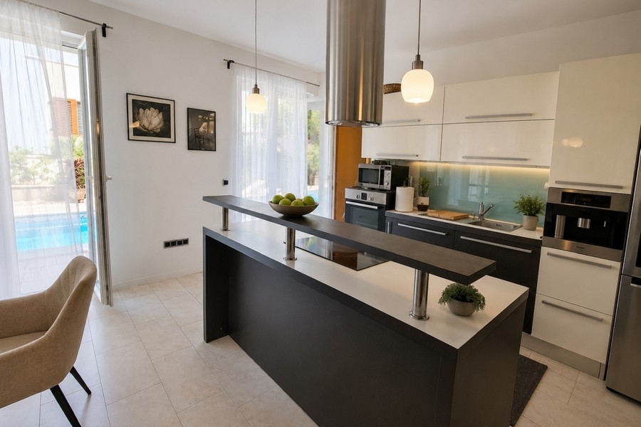 Modern kitchen with cooking island and view of the pool