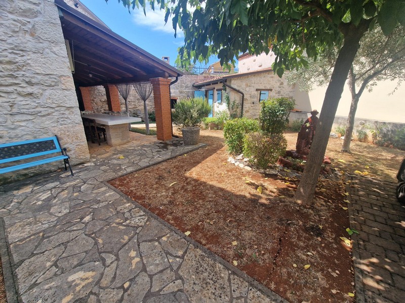 Covered terrace and garden of the stone house