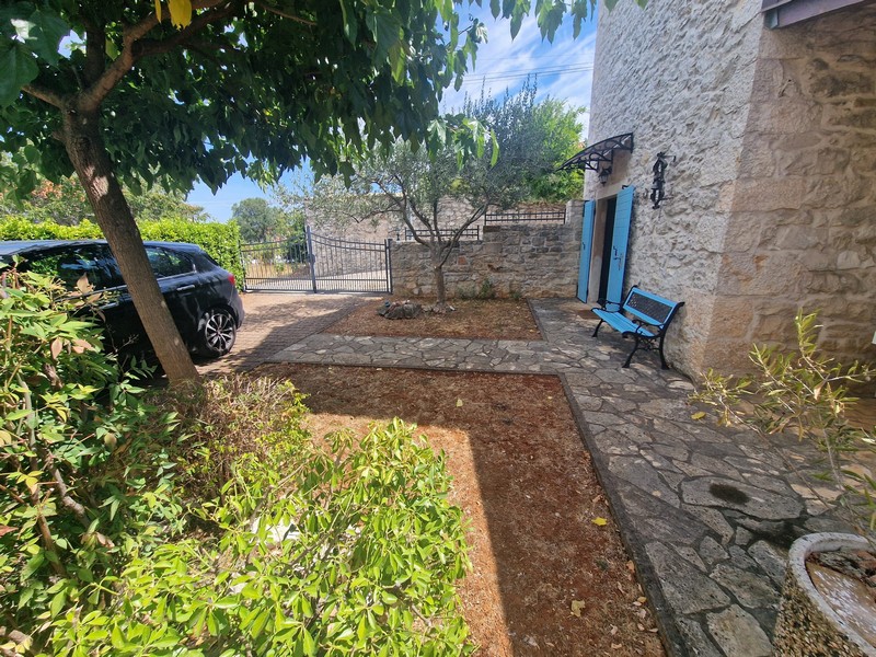 Garden with parking space in front of the stone house