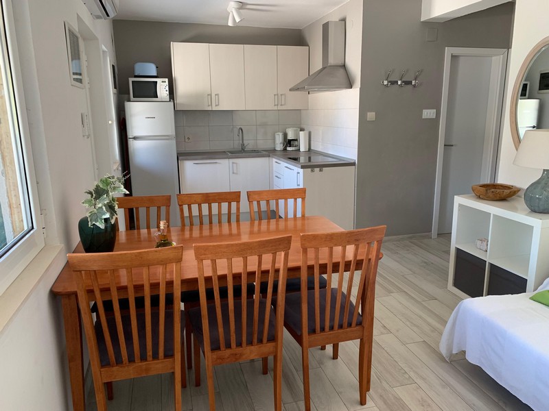 Kitchen with dining table in an apartment of the house in Povlja on Brac