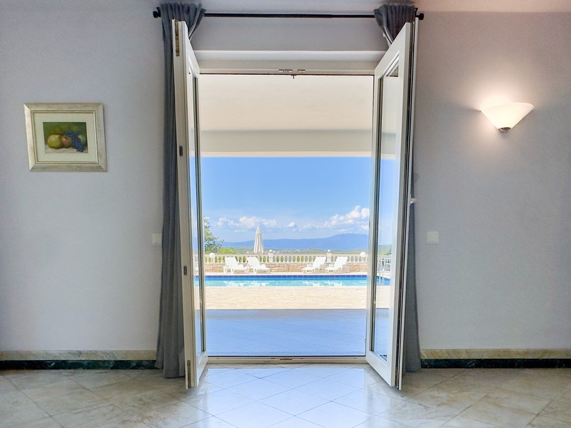 View through the patio door of the pool and sea