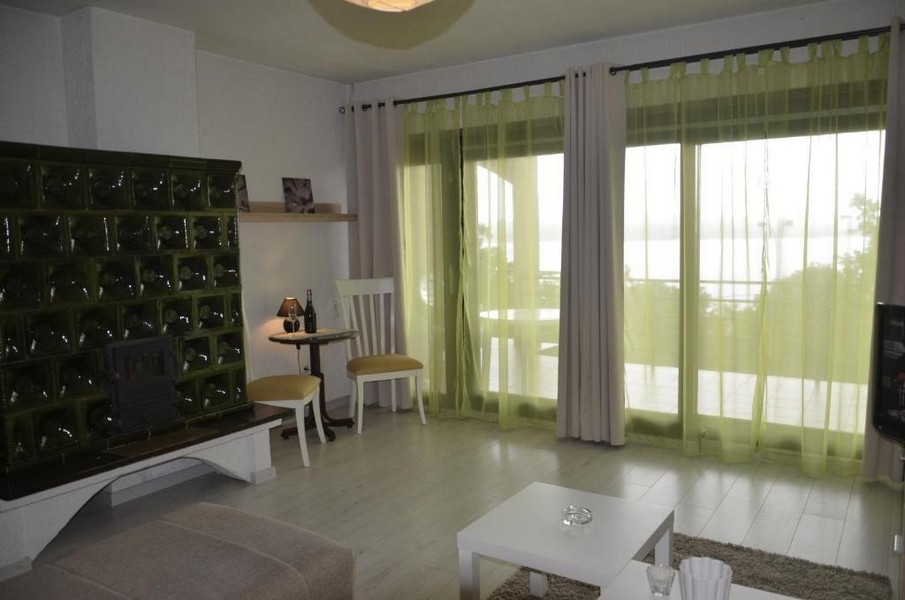 Living room with tiled stove and large patio doors in Crikvenica