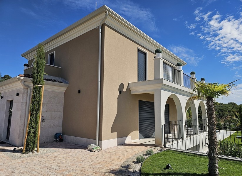 Exterior view of the villa with arcades and palm trees
