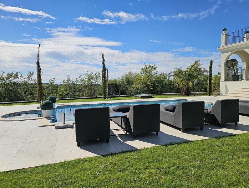 Pool terrace with lounge furniture and lawn area