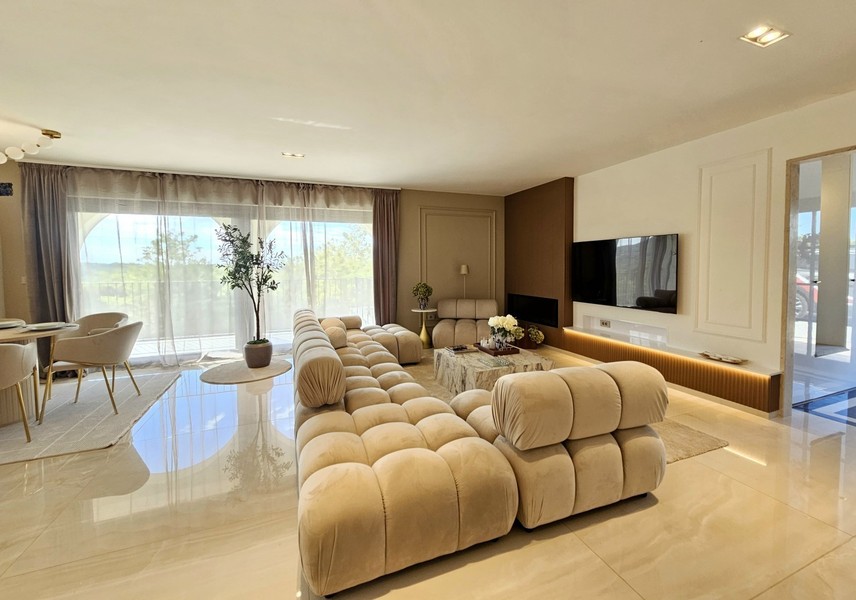 Open living area with marble floors and TV wall