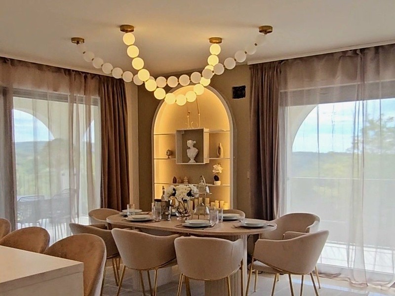 Dining area with large windows and a view of the greenery