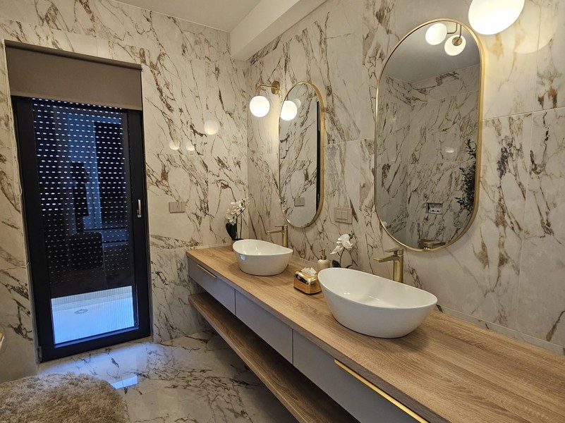 Bathroom with marble walls and countertop sink