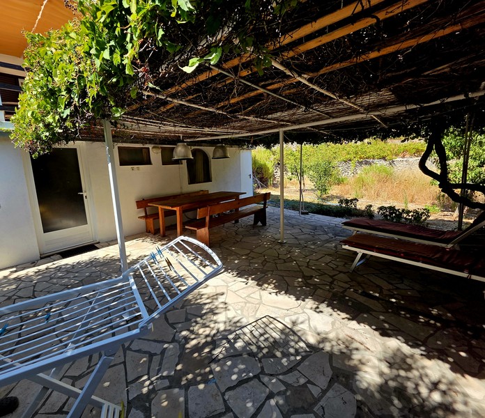 Shady terrace with natural stone flooring in front of the house