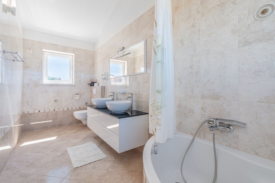Bathroom with bathtub and two sinks near Porec