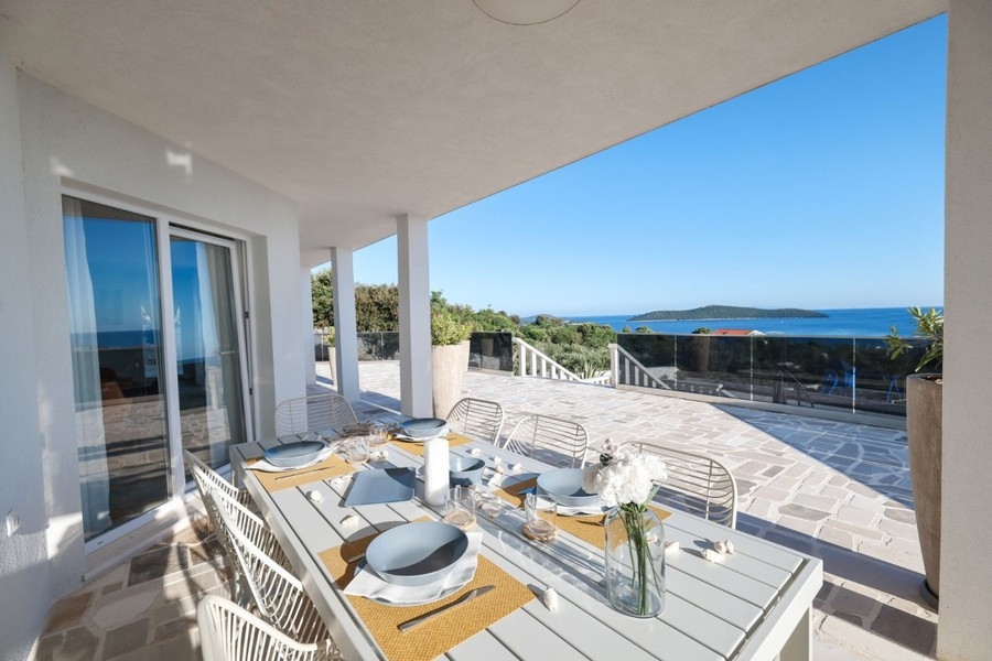 Covered terrace with dining table by the pool