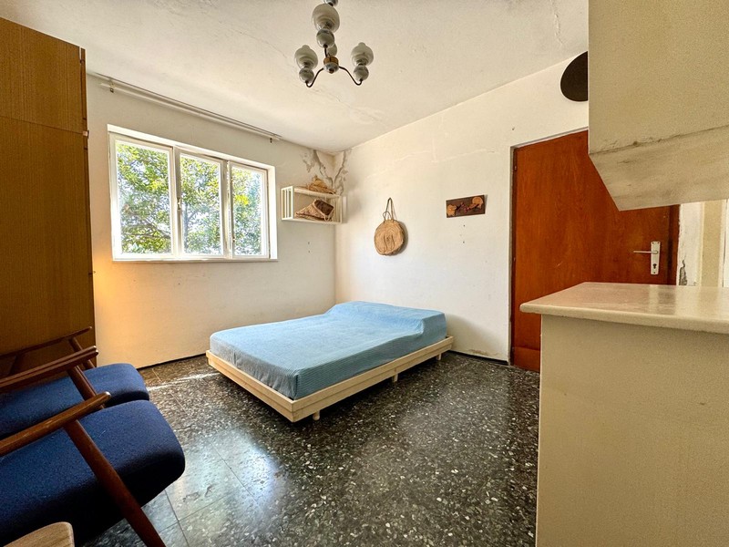 Room with bed and large window