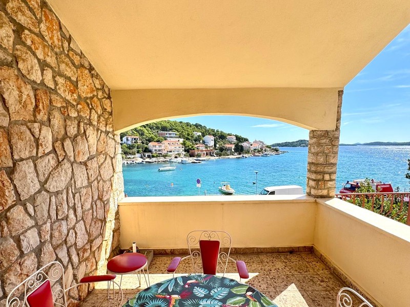 Covered terrace with stone wall and sea views