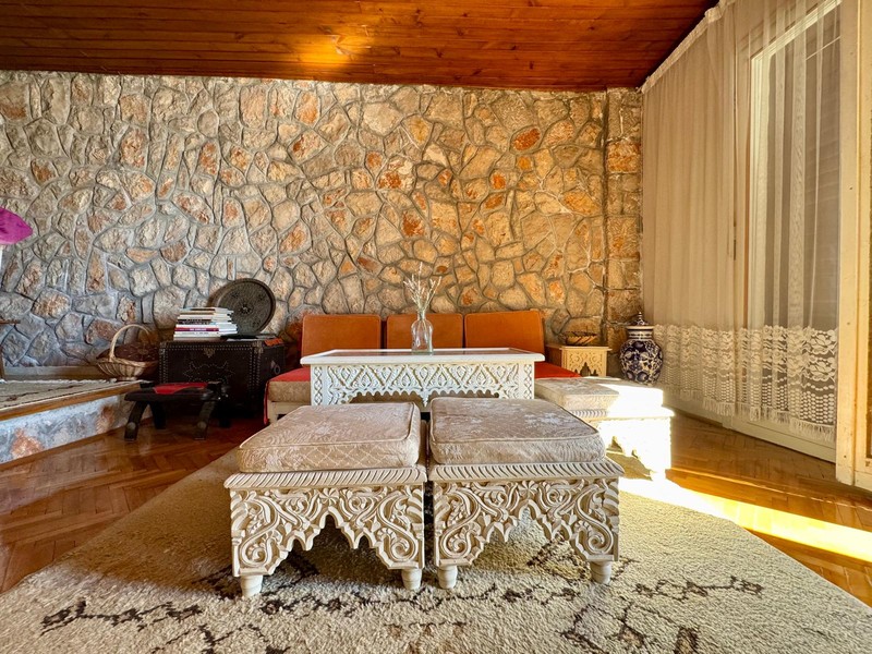 Living room with stone wall and wooden floor