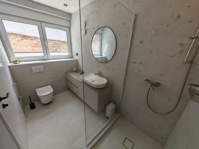 Bathroom with shower and round mirror