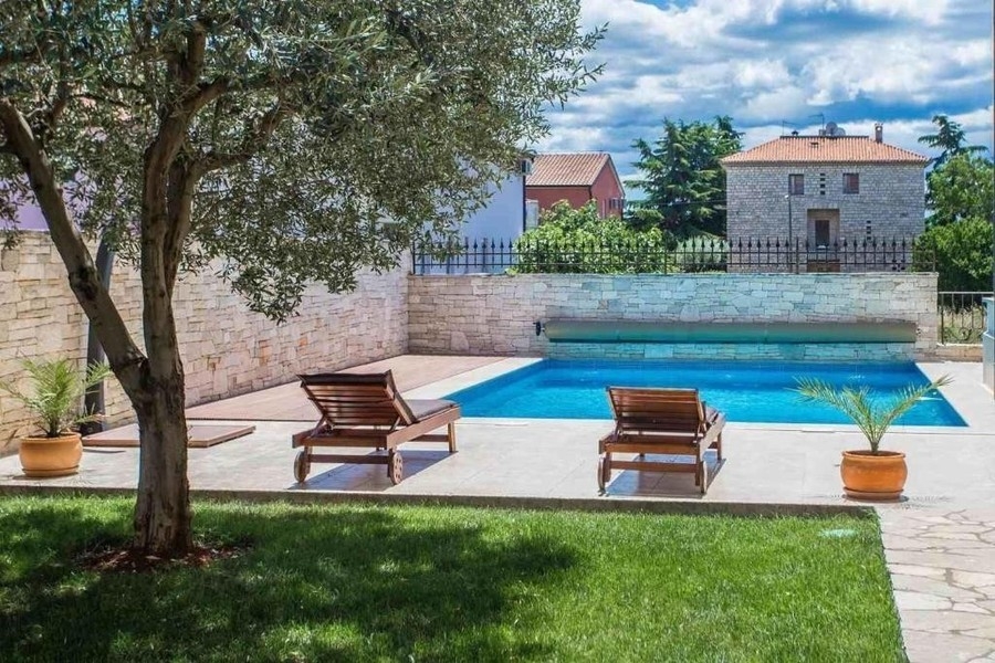 Heated pool with sun loungers in the garden