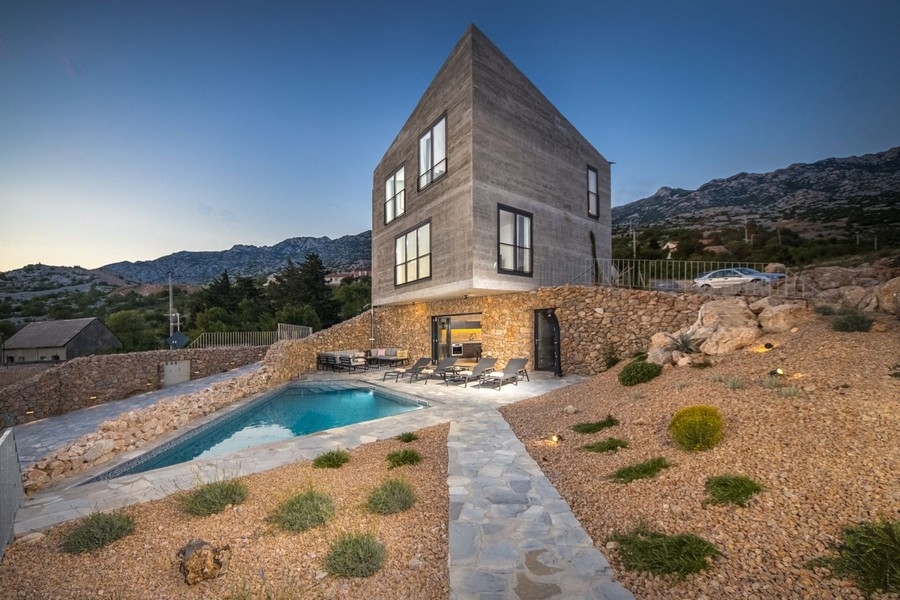 Exterior of the villa with pool in the evening