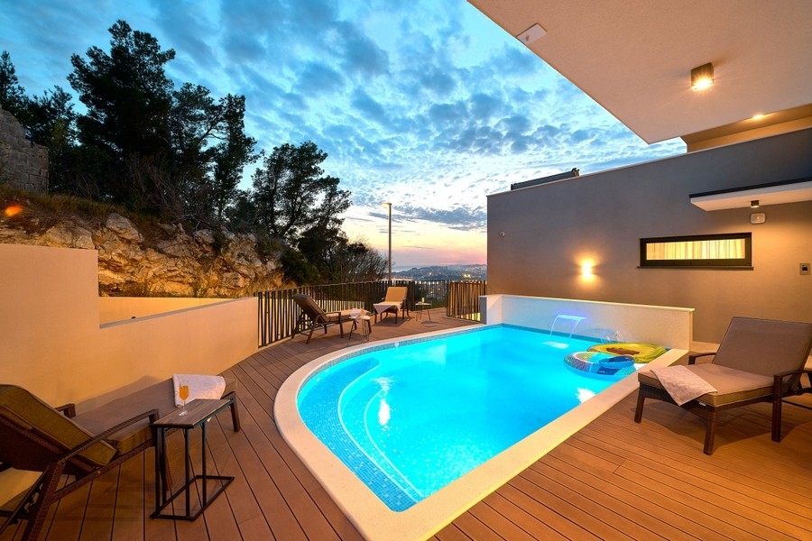 Swimming pool with loungers at dusk
