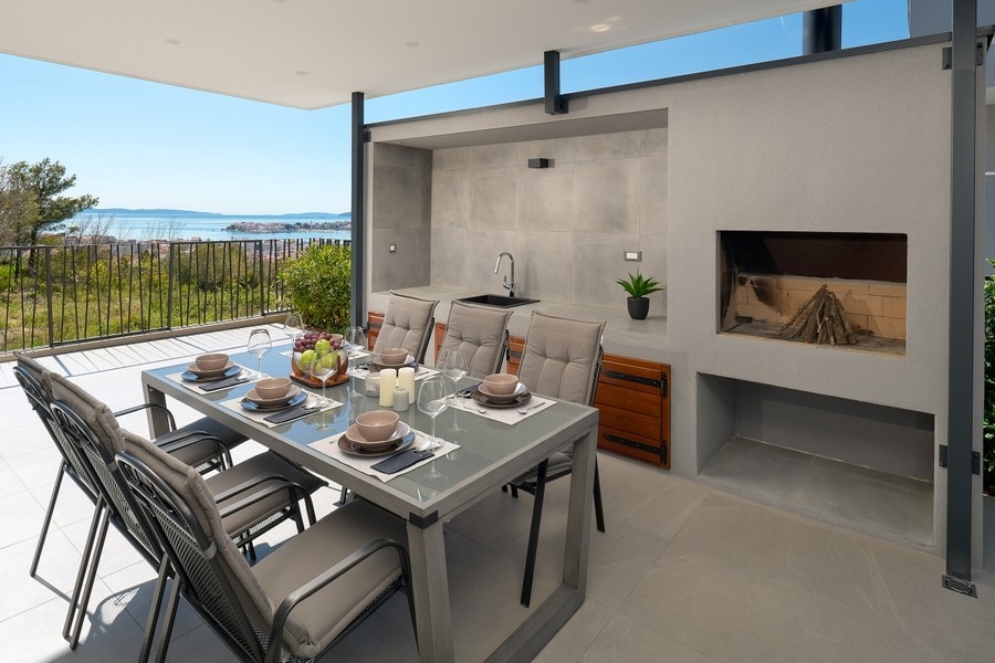 Covered summer kitchen with dining table and sea views