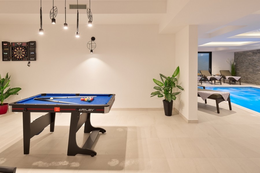 Leisure room with pool table by the indoor pool