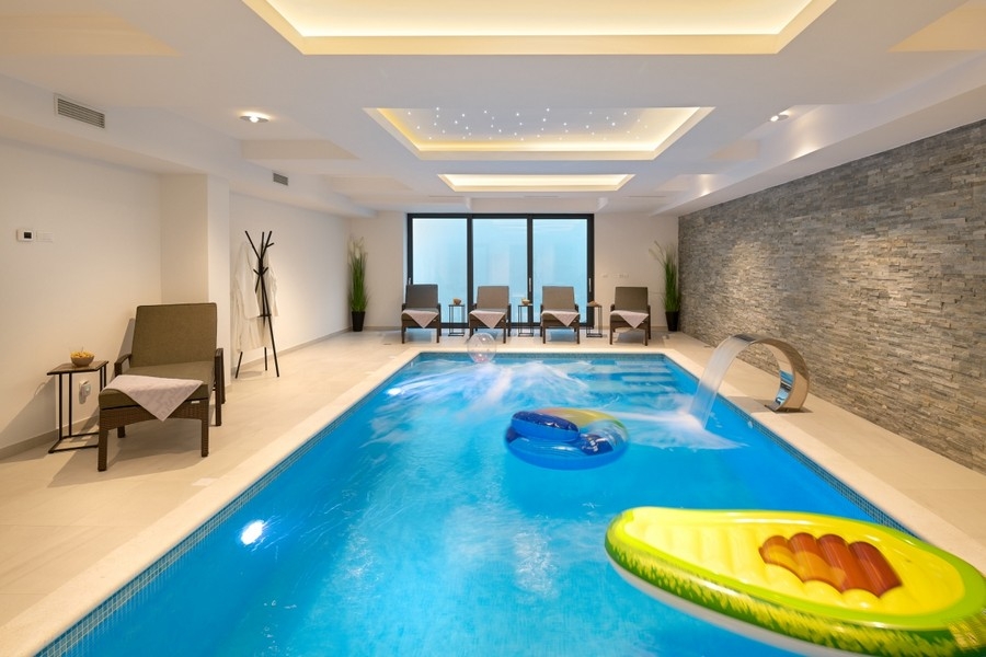 Illuminated indoor pool with natural stone wall