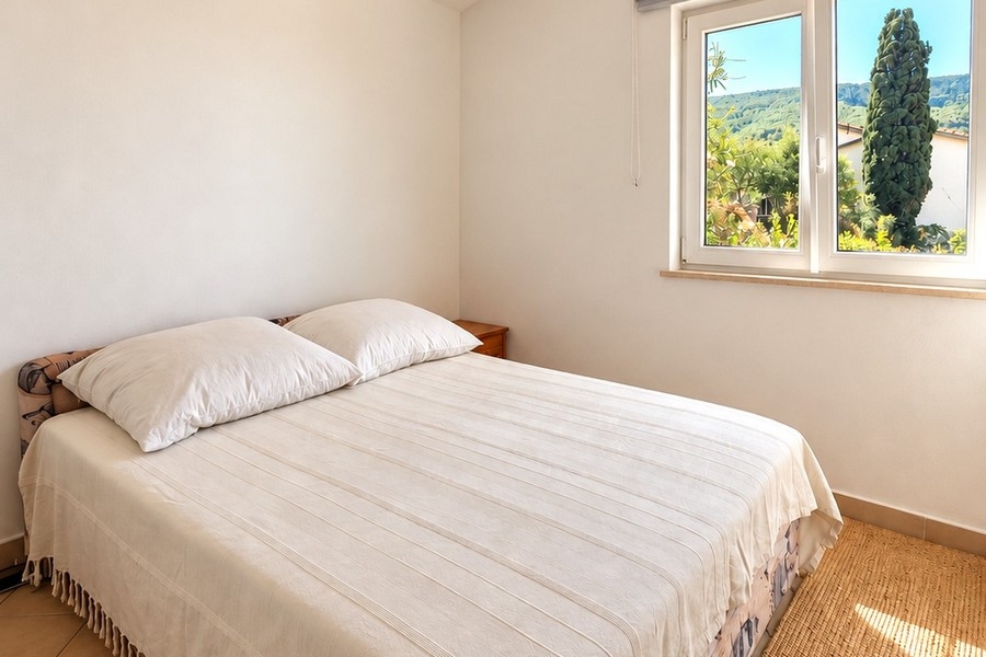 Bright bedroom with double bed and view of the greenery