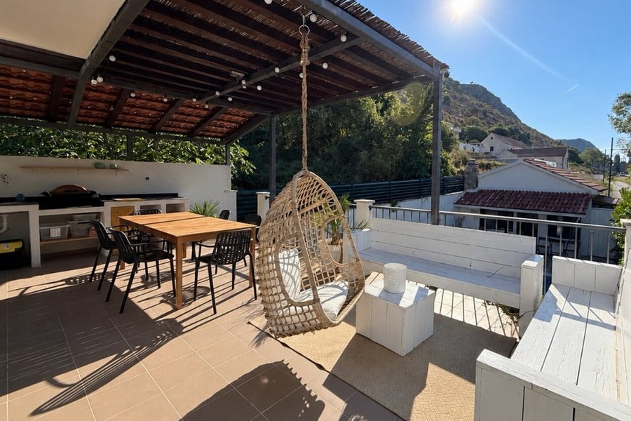 Covered terrace with outdoor kitchen and seating area