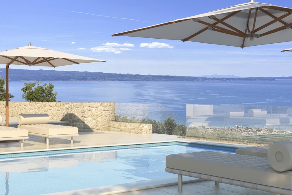 Swimming pool with lounge area and wide sea views