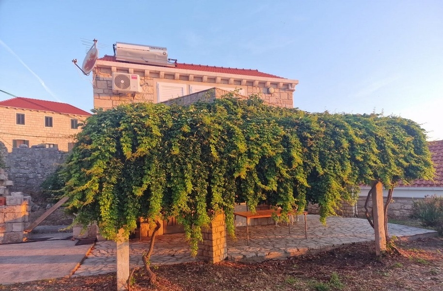 Stone house with green pergola and terrace