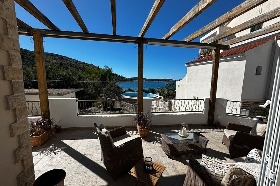 Covered terrace with seating area and sea views