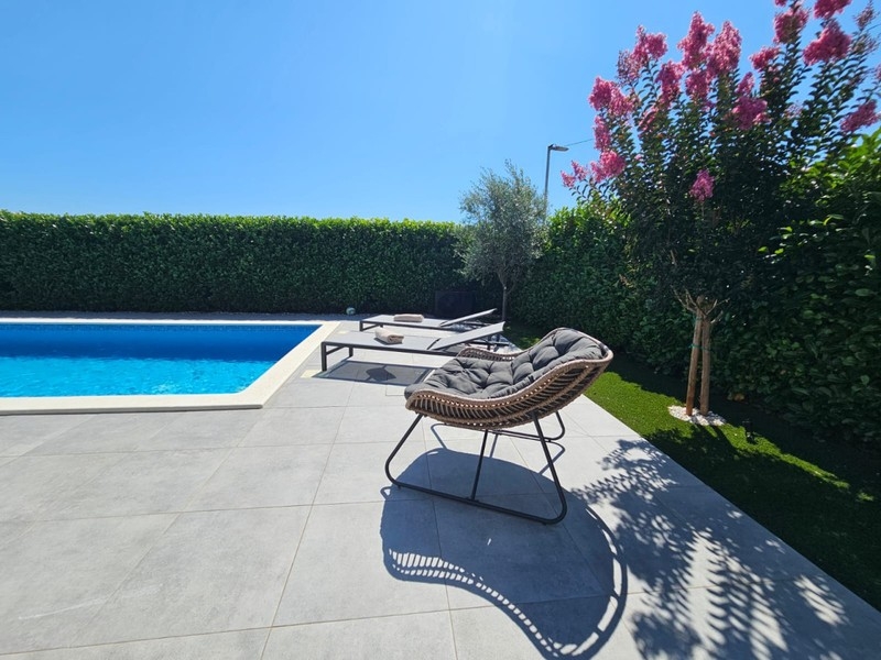 Swimming pool with sunbathing area and loungers
