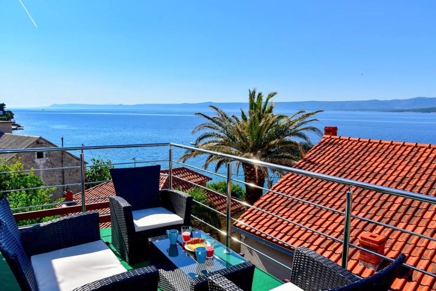 Apartment house with sea views on the island of Brac, terrace with palm trees