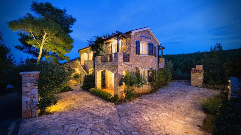 Stone house in the evening with illuminated courtyard