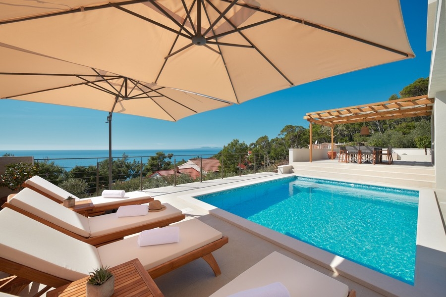 Pool terrace with sun loungers and parasol
