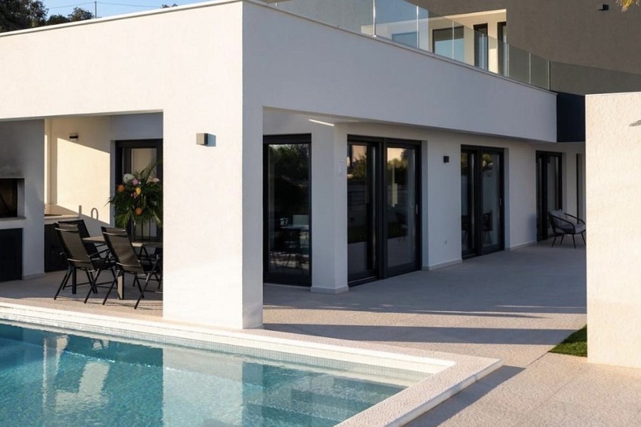 Swimming pool in front of the covered terrace of the villa