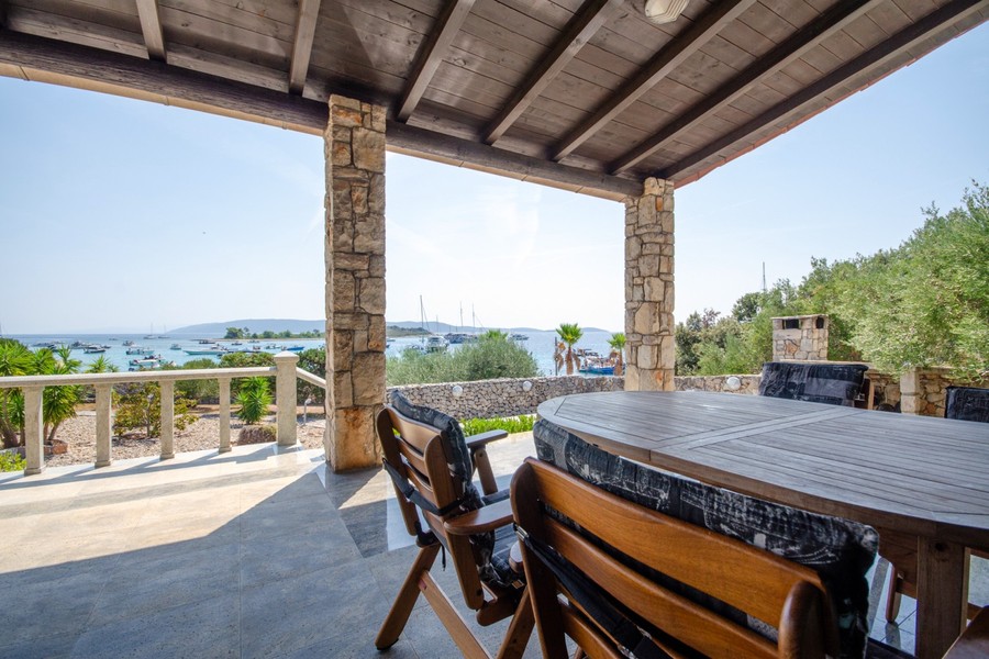 Covered terrace with dining table and sea views