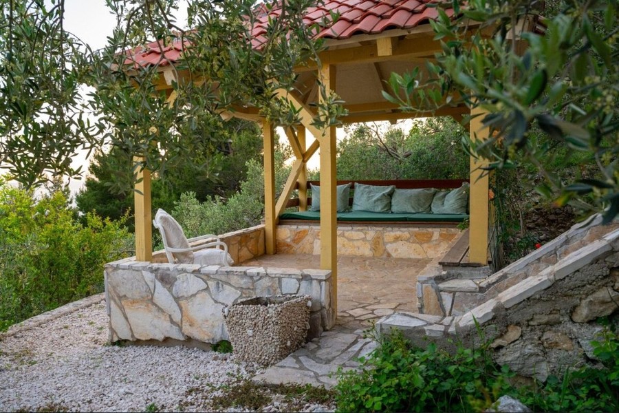 Pergola with bench between olive trees