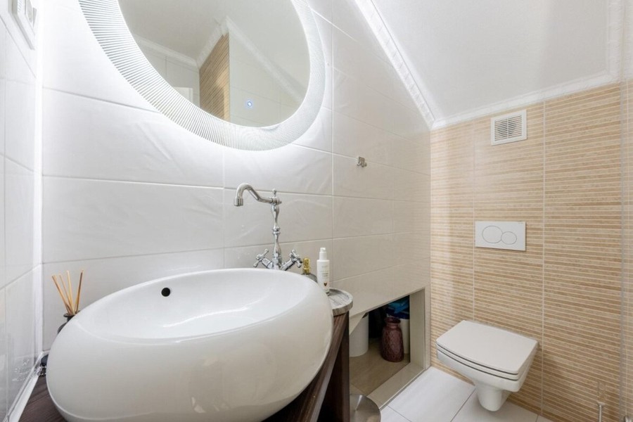 Bathroom with countertop washbasin and round mirror