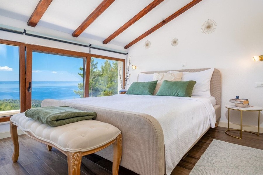 Bedroom with large window front facing the sea